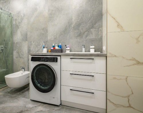 Mueble de baño blanco con lavabo y hueco para la lavadora bajo la encimera