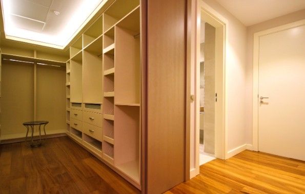 Vestidor abierto con luz LED en el techo y puerta corredera de madera
